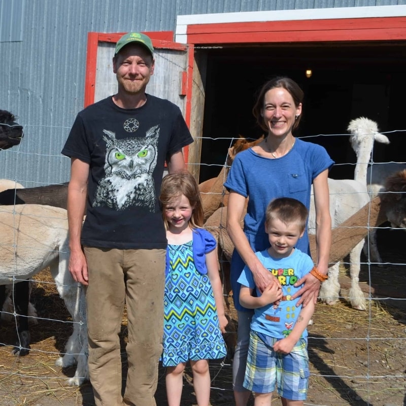 Photo de famille : propriétaires de la ferme et leurs enfants devant des alpagas